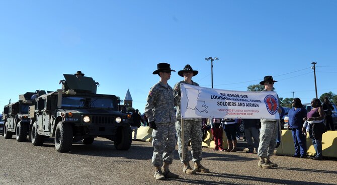 Louisiana Army National Guard Soldiers march with their High Mobility Multipurpose Wheeled Vehicles, or humvees, during the Veterans Parade at State Fair of Louisiana in Shreveport, La., Nov. 8, 2015. The humvee is an all-wheel drive military automobile designed primarily for personnel and light cargo transport. (U.S. Air Force photo/ Senior Airman Joseph Raatz)