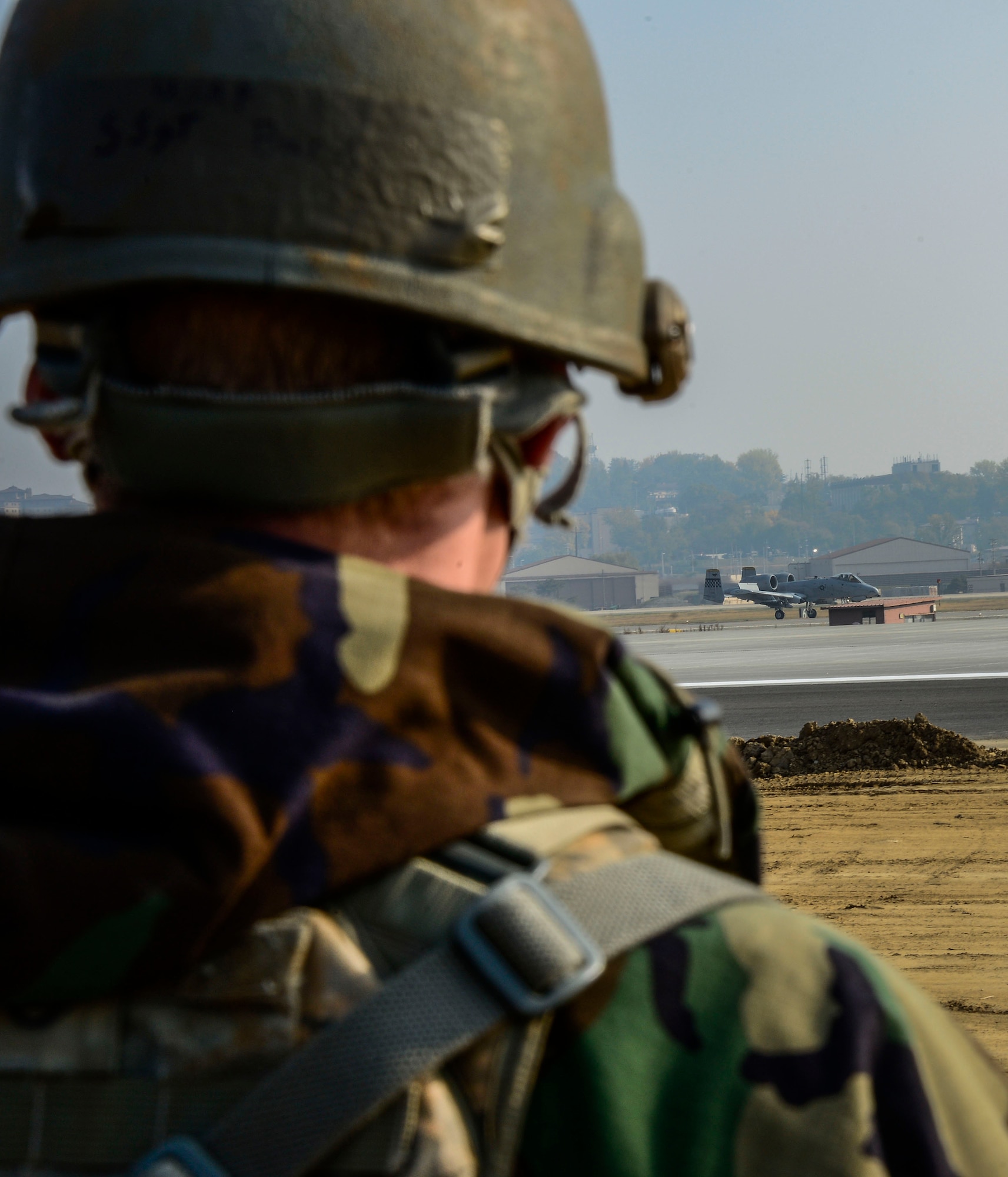 Staff Sgt. Raymond Burk, 35th Security Forces Squadron, Misawa Air Base, Japan, base defense operations center controller, watches an A-10 Thunderbolt II fighter aircraft prepare to take off during readiness exercise Vigilant Ace 16 on Osan Air Base, Republic of Korea, Nov. 4, 2015. Throughout the week-long, peninsula-wide exercise, more than 16,000 participants demonstrated the ability to operate in a chemical environment as well as administer self-aid buddy care during a wartime environment. These defenders highlighted their ability to position, employ and sustain forces and showcase operational readiness. (U.S. Air Force photo/Senior Airman Kristin High)