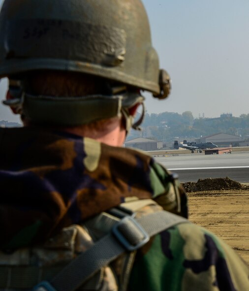Staff Sgt. Raymond Burk, 35th Security Forces Squadron, Misawa Air Base, Japan, base defense operations center controller, watches an A-10 Thunderbolt II fighter aircraft prepare to take off during readiness exercise Vigilant Ace 16 on Osan Air Base, Republic of Korea, Nov. 4, 2015. Throughout the week-long, peninsula-wide exercise, more than 16,000 participants demonstrated the ability to operate in a chemical environment as well as administer self-aid buddy care during a wartime environment. These defenders highlighted their ability to position, employ and sustain forces and showcase operational readiness. (U.S. Air Force photo/Senior Airman Kristin High)