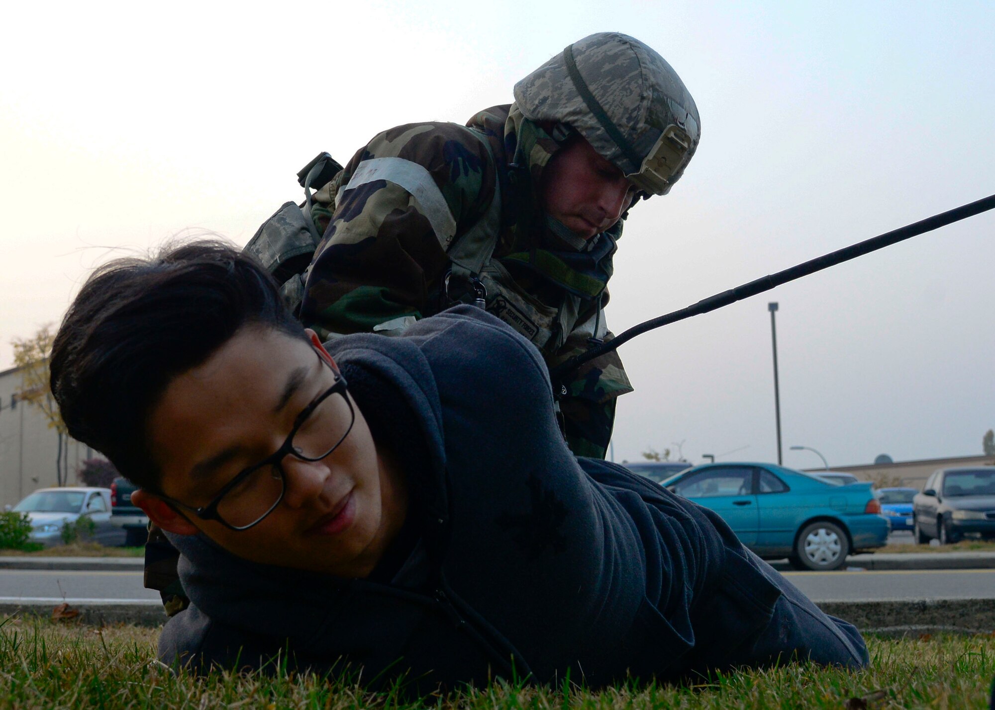 Senior Airman Sang Chung, 51st Security Forces Squadron, is detained during readiness exercise Vigilant Ace 16, on Osan Air Base, Republic of Korea, Nov. 4, 2015. Chung, along with other Defenders and augmentees from the 35th SFS, Misawa Air Base, Japan, played opposing forces to simulate real-world conditions. (U.S. Air Force photo/Senior Airman Kristin High)