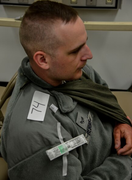 Senior Airman Nicholas Burns, 51st Dental Squadron prophylactics technician, acts as an augmentee during readiness exercise Vigilant Ace 16 on Osan Air Base, Republic of Korea, Nov. 3, 2015. Burns simulated having a broken wrist and was triaged and given an IV with pain medication. (U.S. Air Force photo/Senior Airman Kristin High)