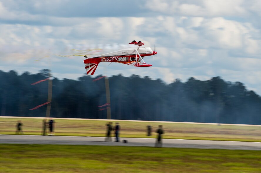 A civilian airshow performer flies upside down during the Thunder Over South Georgia airshow, Nov. 7, 2015, at Moody Air Force Base, Ga. The pilot flew in between two poles breaking a ribbon. (U.S. Air Force photo by Staff Sgt. Eric Summers Jr./Released)