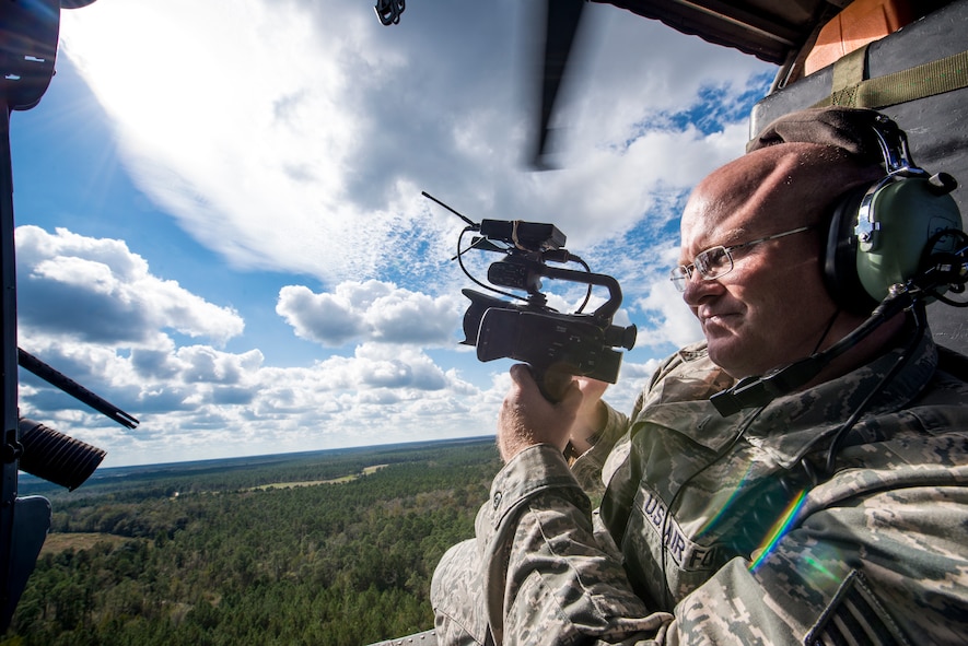 U.S. Air Force Staff Sgt. Timothy Gallagher, 23d Wing  broadcast journeyman, rides in an HH-60G Pave Hawk during the Thunder Over South Georgia Open House practice, Nov. 6, 2015, at Moody Air Force Base, Ga. As a broadcaster, Gallagher is responsible for capturing, documenting and telling the story of the Air Force and it’s Airmen. (U.S. Air Force photo by Senior Airman Ryan Callaghan/Released)
