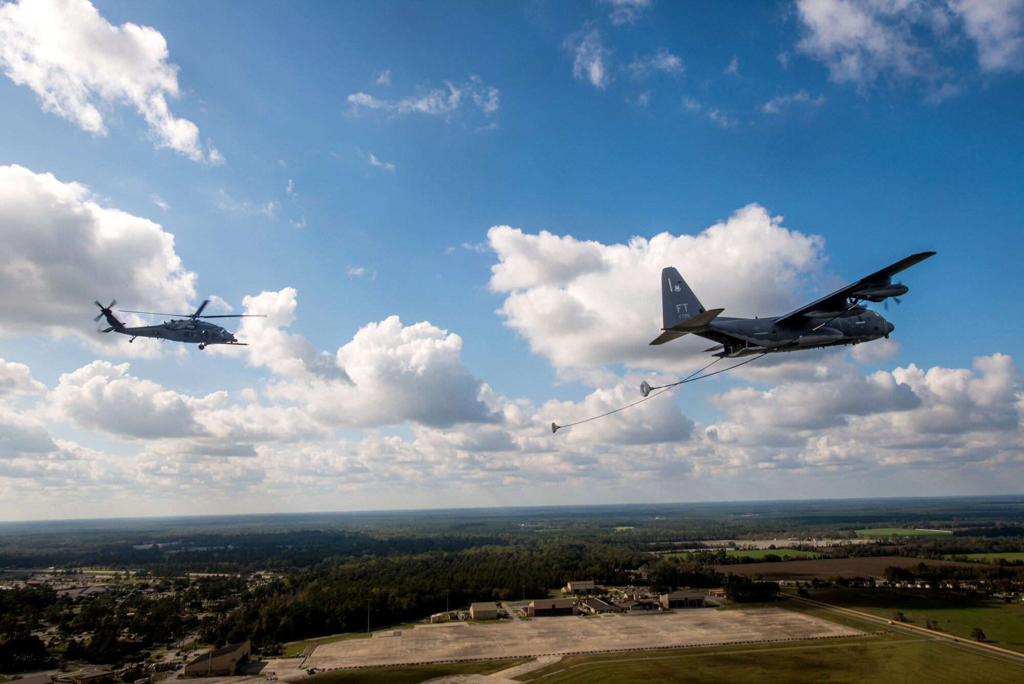 An HH-60G Pave Hawk, foreground, flies toward an HC-130J Combat King II during the Thunder Over South Georgia Open House practice, Nov. 6, 2015, at Moody Air Force Base, Ga.  The HC-130J is the Air Force’s newest dedicated, fixed-wing personnel recovery platform and is tasked to perform airdrop, helicopter air-to-air refueling, humanitarian assistance and aeromedical evacuations (U.S. Air Force photo by Senior Airman Ryan Callaghan/Released)
