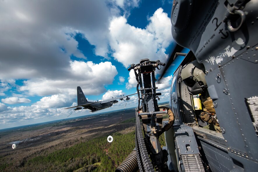 U.S. Air Force Tech. Sgt. Tareek Johnson, 41st Rescue Squadron special missions aviator, looks out of an HH-60G Pave Hawk toward an HC-130J Combat King II during a refueling demonstration at the Thunder Over South Georgia Open House practice, Nov. 6, 2015, at Moody Air Force Base, Ga.  In addition to serving as aerial gunners, SMAs are also responsible for preflight and postflight aircraft inspections and ensuring the safety of passengers and equipment during flight. (U.S. Air Force photo by Senior Airman Ryan Callaghan/Released)
