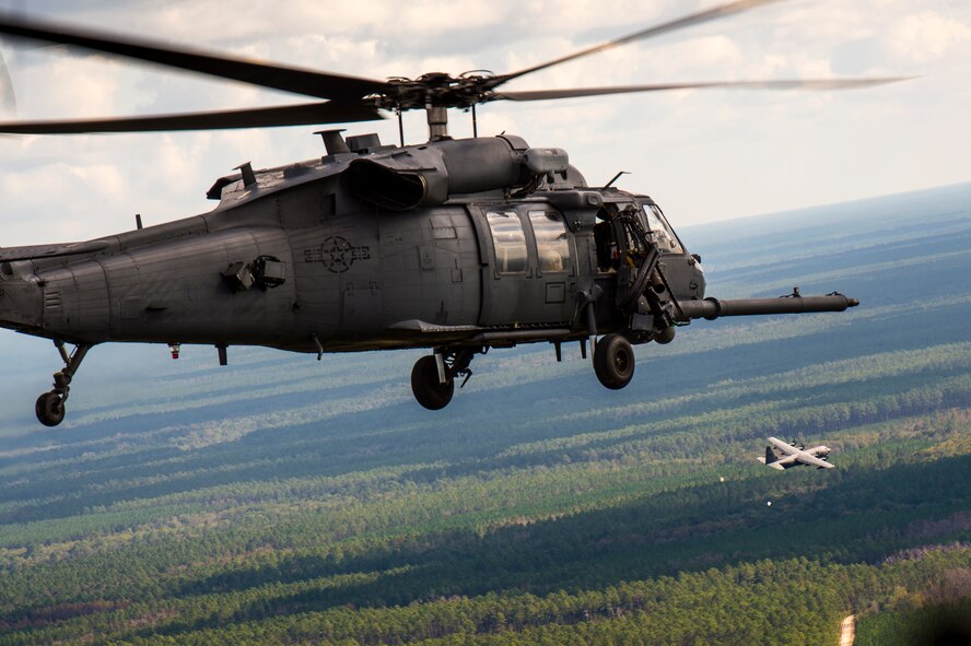 An HH-60G Pave Hawk, foreground, flies toward an HC-130J Combat King II during the Thunder Over South Georgia Open House practice, Nov. 6, 2015, at Moody Air Force Base, Ga. The HH-60G was carrying pararescuemen from the 38th Rescue Squadron for a combat search and rescue demonstration. (U.S. Air Force photo by Senior Airman Ryan Callaghan/Released)
