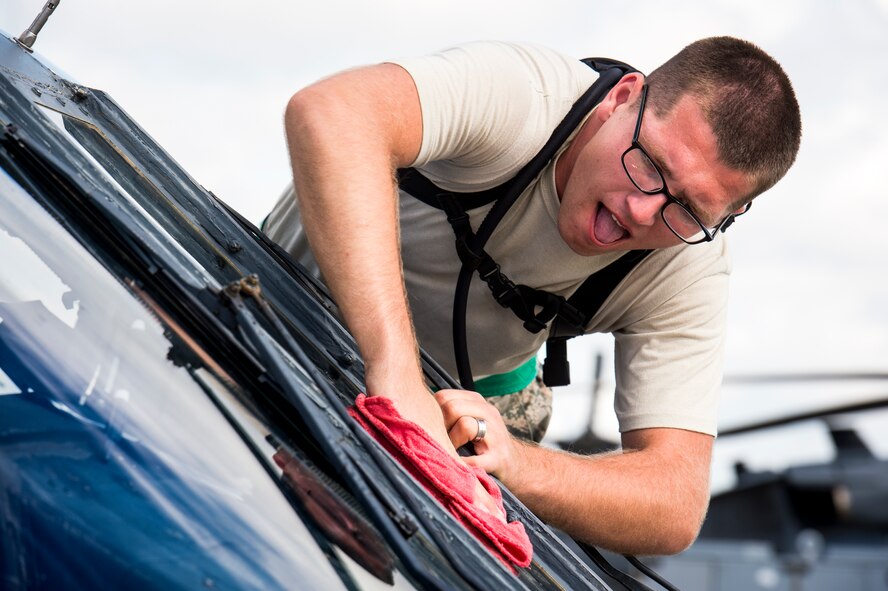 U.S. Air Force Airman 1st Class Thomas Kraskowski, 41st Helicopter Maintenance Unit crew chief, washes the windshield on an HH-60G Pave Hawk before the combat search and rescue demonstration at the Thunder Over South Georgia Open House Nov. 7, 2015, at Moody Air Force Base, Ga. The CSAR demonstration showcased Moody's capabilities in a deployed environment.  (U.S. Air Force photo by Senior Airman Ryan Callaghan/Released)

