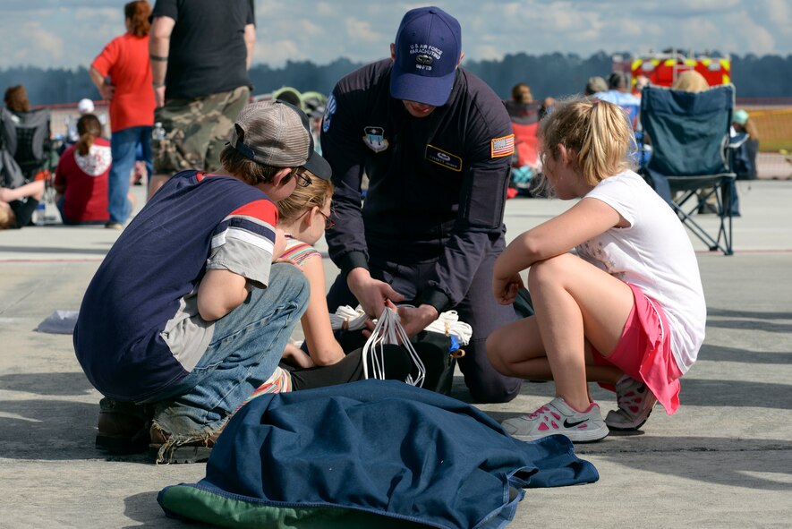 David, and Renee Mayhorn son and daughter of Beatrice Mayhorn and Mackenzie Atkins, daughter of Mary Atkins, help U.S. Air Force Cadet Everett Joiner, U.S. Air Force Wings of Blue Sky diving team member, re-pack his parachute during Thunder Over South Georgia, Nov. 7, 2015, at Moody Air Force Base, Ga. The Wings of Blue demonstration team travels across the country to showcase precision parachuting. (U.S. Air Force photo by Airman 1st Class Janiqua P. Robinson/Released)