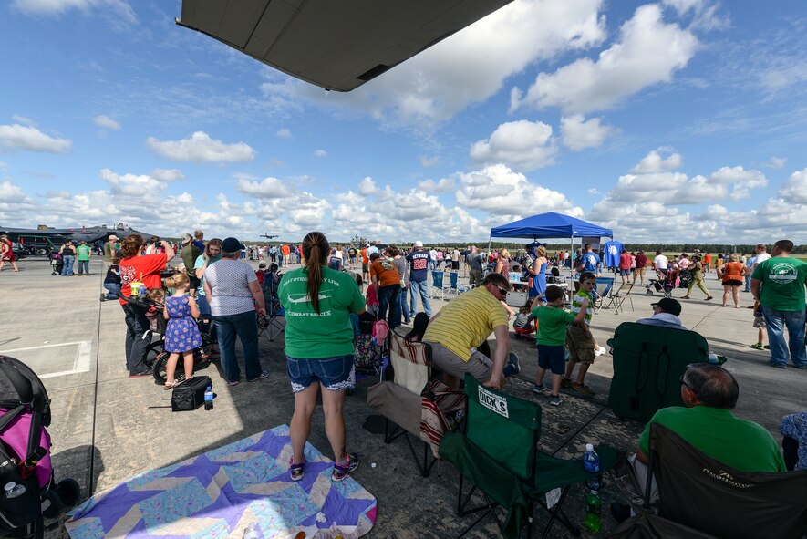 Thousands of people watch from under a Lockheed Martin C-5 Galaxy as an HC-130J Combat King II comes in for a landing during Thunder Over South Georgia, Nov. 7, 2015, at Moody Air Force Base, Ga. The open house included aerial performances, food, face painting and much more. (U.S. Air Force photo by Airman 1st Class Janiqua P. Robinson/Released)