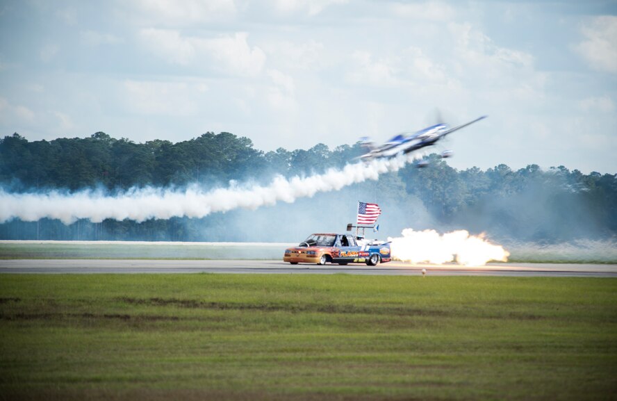 Rob Holland flies in an MXS aircraft over the Flash Fire Jet truck during the Thunder Over South Georgia Open House Nov. 7, 2015, at Moody Air Force Base, Ga. The truck can reach speeds up to 400 mph. (U.S. Air Force photo by Senior Airman Olivia Dominique/Released)
