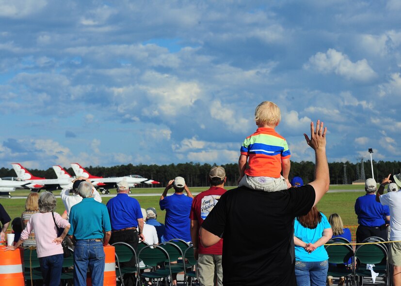 A father and son wave on the Thunderbirds as they begin their performance at the Thunder over South Georgia Open House Nov. 7 at Mood Air Force Base, Georgia. The Thunderbirds are the United States Air Force Demonstration Squadron and they were the final act to perform. (U.S. Air Force photo/Senior Airman Stephanie Englar)