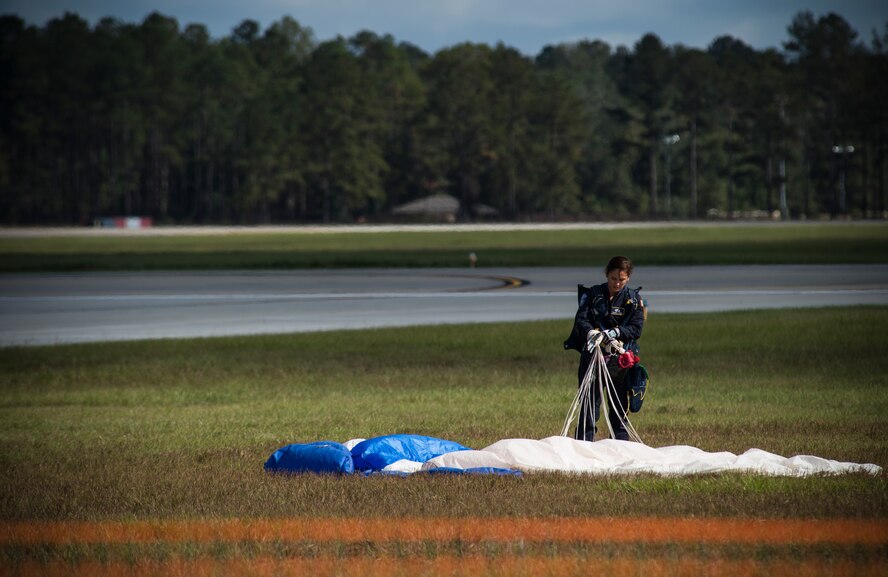 U.S. Air Force Academy Wings of Blue Parachute Team member Charlene Blair gathers her parachute after jumping from an HC-130J Combat King II during the Thunder Over South Georgia Open House, Nov. 7, 2015, at Moody Air Force Base, Ga. The Wings of Blue are a demonstration team that represents the Air Force in precision parachuting. (U.S. Air Force photo by Senior Airman Olivia Dominique/Released) 