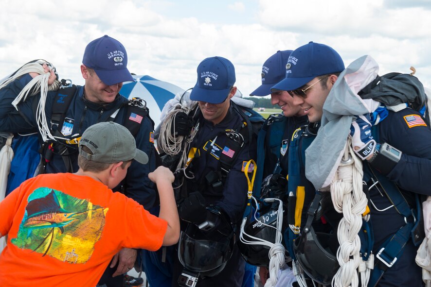 Caleb, son of U.S. Air Force Staff Sgt. Christopher Reynolds, 71st Rescue Squadron, fist bumps members of the U.S. Air Force Academy Wings of Blue Parachute Team during the Thunder Over South Georgia Open House, Nov. 7, 2015, at Moody Air Force Base, Ga. The Wings of Blue are a demonstration team that represents the Air Force in precision parachuting. (U.S. Air Force photo by Senior Airman Ceaira Tinsley/Released)