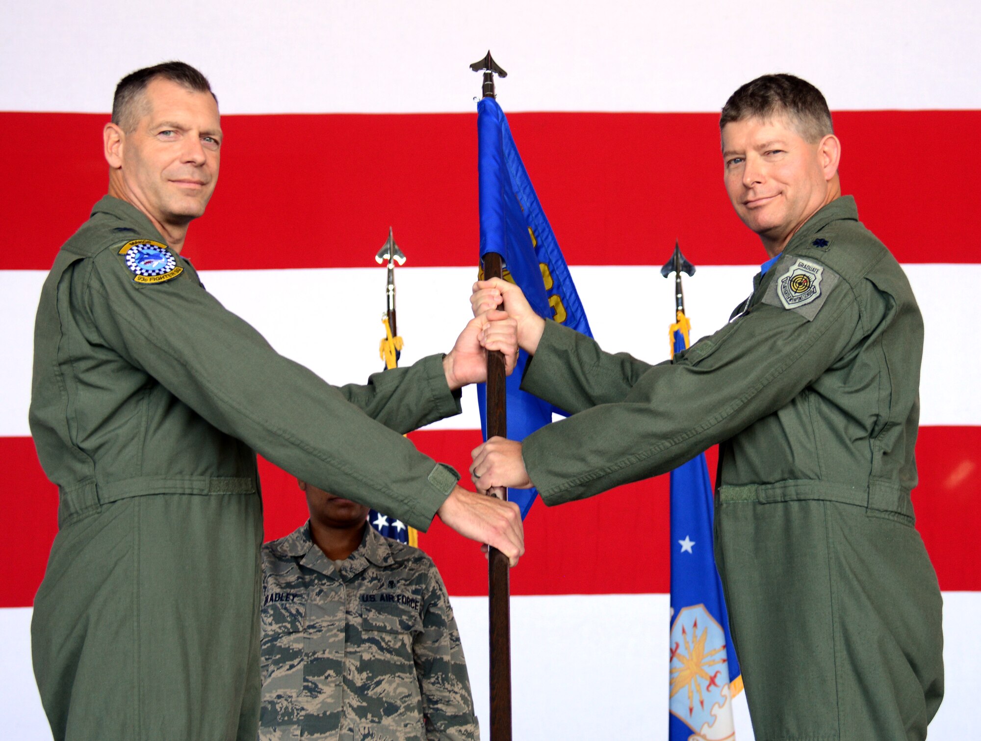 Col. David P. Garfield, left, the 482nd Fighter Wing commander, passes the 482nd Operations Group guidon to Lt. Col. Michael F. Lesman as he assumes command of the 482nd OG during a change-of-command ceremony at Homestead Air Reserve Base, Fla., in Hangar 200. (U.S. Air Force photo/Senior Airman Frank Casciotta) 