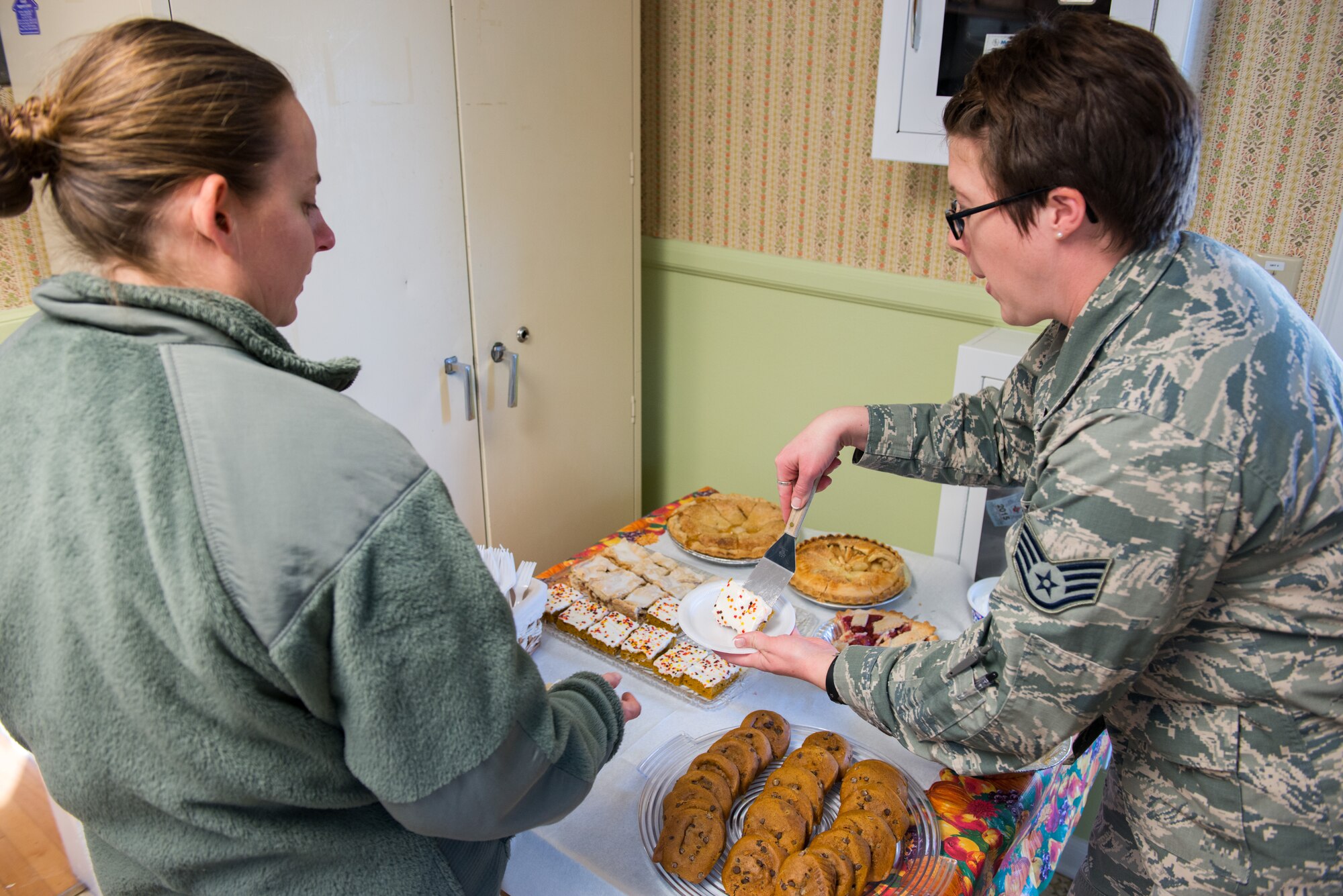 Chaplain's Assistant, Staff Sgt. Serina Peterson, provides homemade treats to Senior Airman Amber Schneider, 27th Aerial Port Squadron, at the Chapel/Honor Guard social, Nov. 8. (U.S. Air Force photo by Staff Sgt. Trevor Saylor)