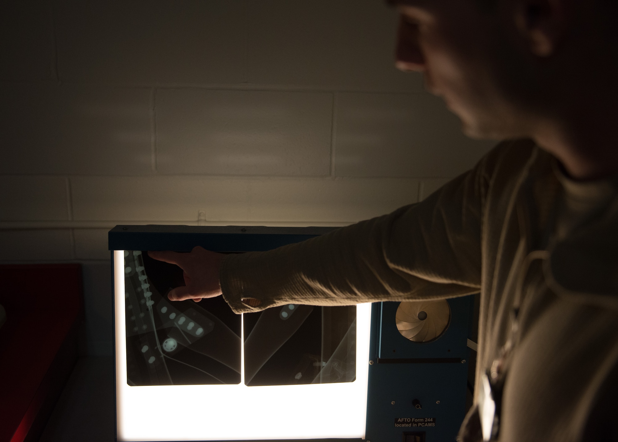 Staff Sgt. Ryan Bauman points to an x-ray image of attach fittings for the fuselage of a C-130, Nov 7. (U.S. Air Force photo by Staff Sgt. Trevor Saylor)