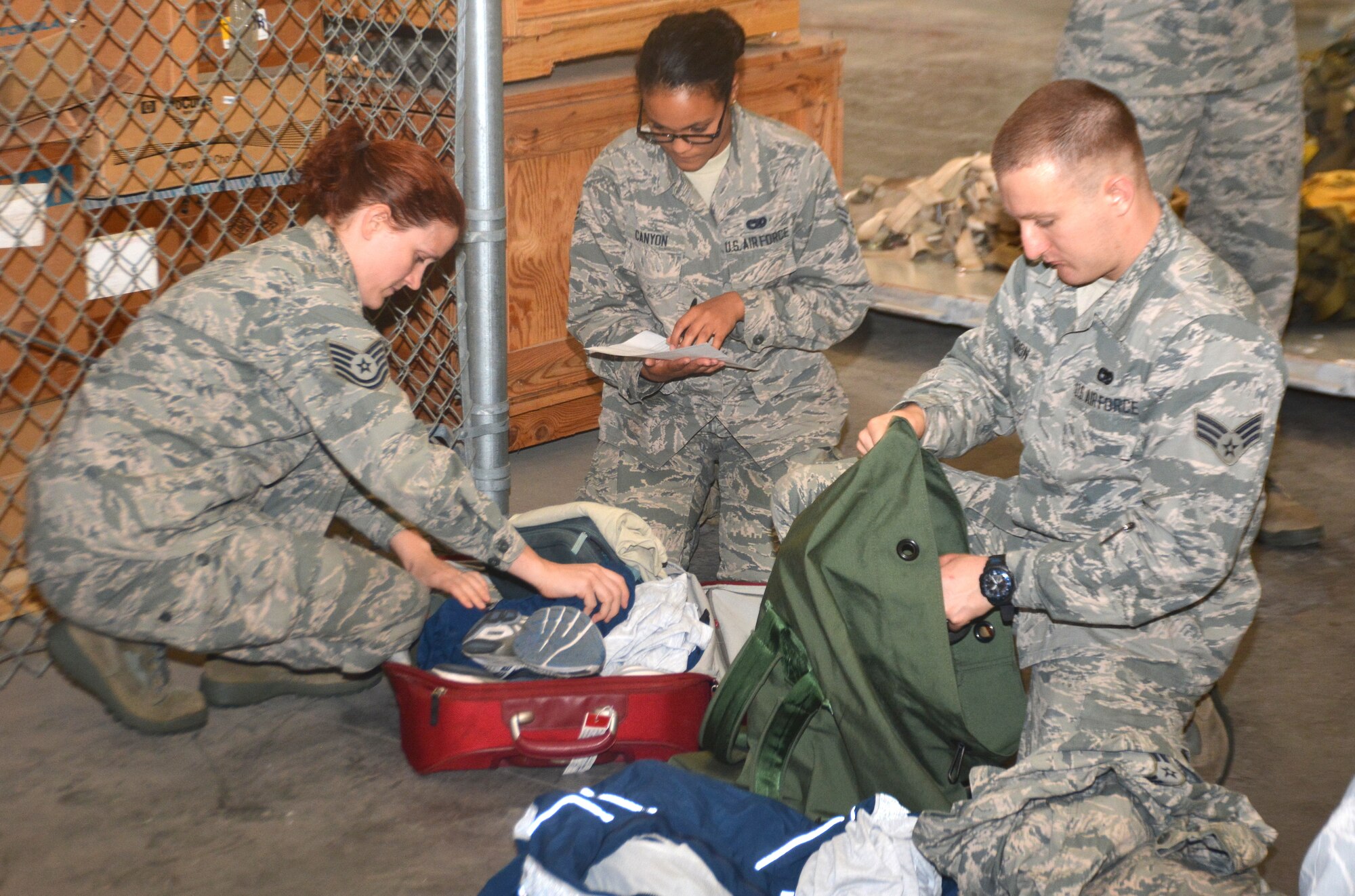 Members of the 26th and 74th Aerial Port Squadrons unload their readiness bags during a routine bag drop at Joint Base San Antonio-Lackland Nov. 11, 2015. The purpose of the bag drop is to ensure the required deployment gear is on-hand and ready in case of a short-notice deployment tasking that may suddenly happen upon the unit. Members are required to have a specific number of uniforms, gear, and personal hygiene in the bags at all times. (U.S. Air Force photo/Senior Airman Bryan Swink)