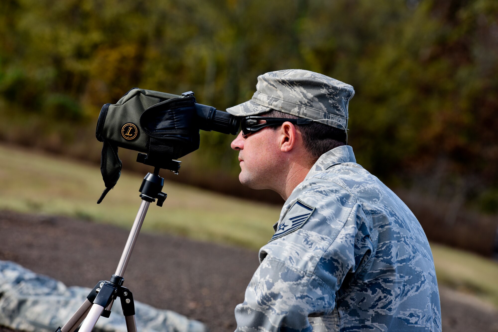 Master Sgt. Brian Detherage, officer in charge of range operations and 188th Security Forces member, watches and provides feedback on target adjustments to fellow 188th Security Forces Squadron Airmen during known distance sniper and advanced designated marksman qualification Nov. 6, 2015 at Fort Chaffee Joint Maneuver Training Center, Ark. 188th SFS members qualified on the M-24 rifle at designated distances of 100, 300, 400 and 500 yards and with moving targets to maintain combat readiness and efficiency as marksmen. (U.S. Air National Guard photo by Capt. Holli Nelson)