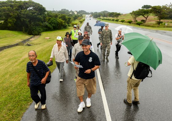 Residents of Chatan Town follow Teruya Youhei, 18th Security Forces Squadron civilian guard, to higher ground during a bilateral tsunami exercise Nov. 5, 2015, at Kadena Air Base, Japan. The exercise entailed the evacuation of local Okinawans from low elevation areas near the Sunabe Seawall to higher ground on base. (U.S. Air Force photo by Senior Airman John Linzmeier)