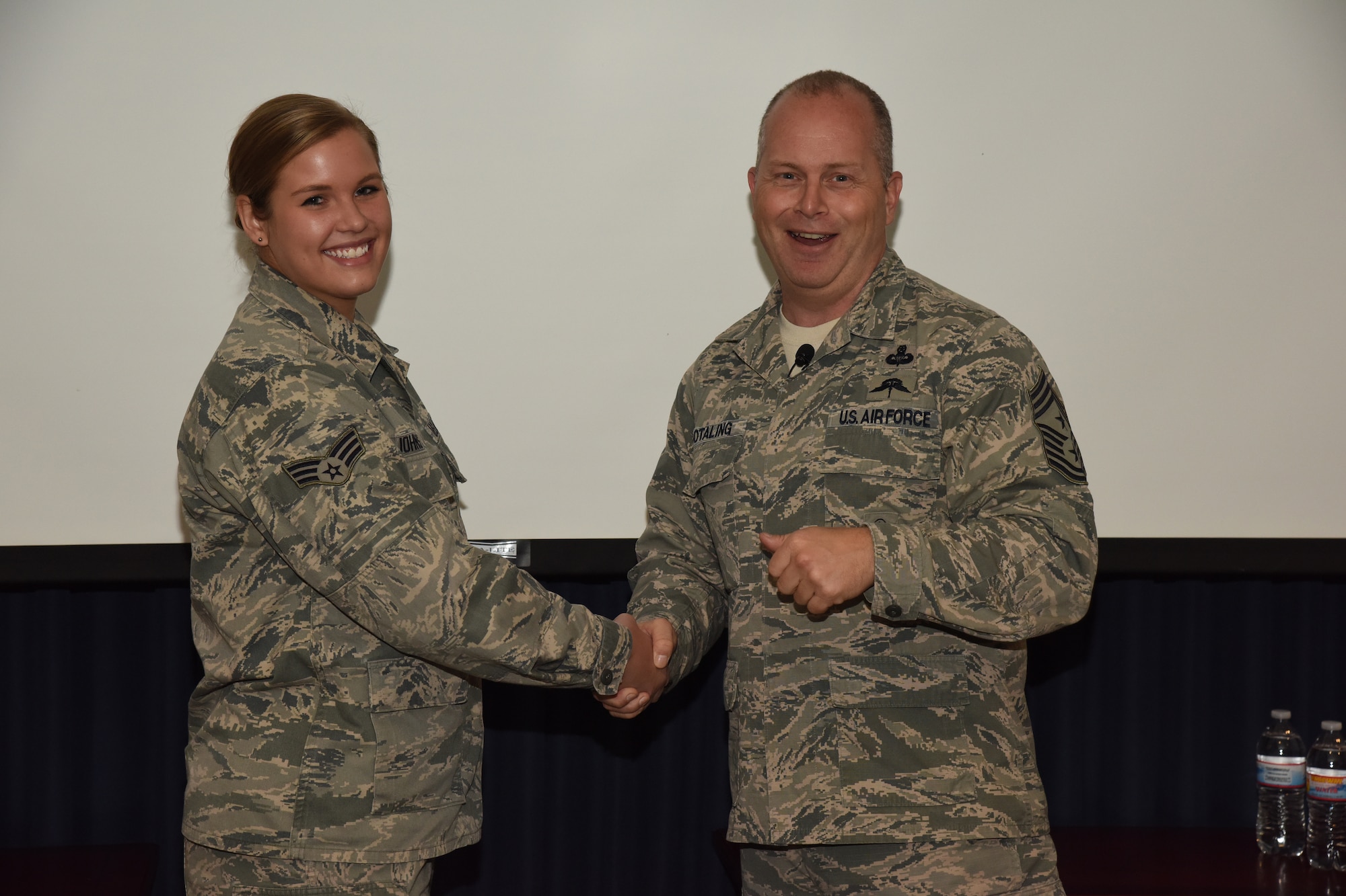 SIOUX FALLS, S.D. - Command Chief Master Sergeant of the Air National Guard James W. Hotaling presents his coin to Senior Airman Katherine Johnston, 114th Operations Group airfield management operations specialist, during his visit to the 114th Fighter Wing, Sioux Falls, S.D.,Nov. 7, 2015. The ANG’s senior enlisted advisor presented eight members of the 114th with his coin to recognize outstanding Airmen from the unit. (U.S. Air National Guard photo by Staff Sgt. Luke Olson/Released)