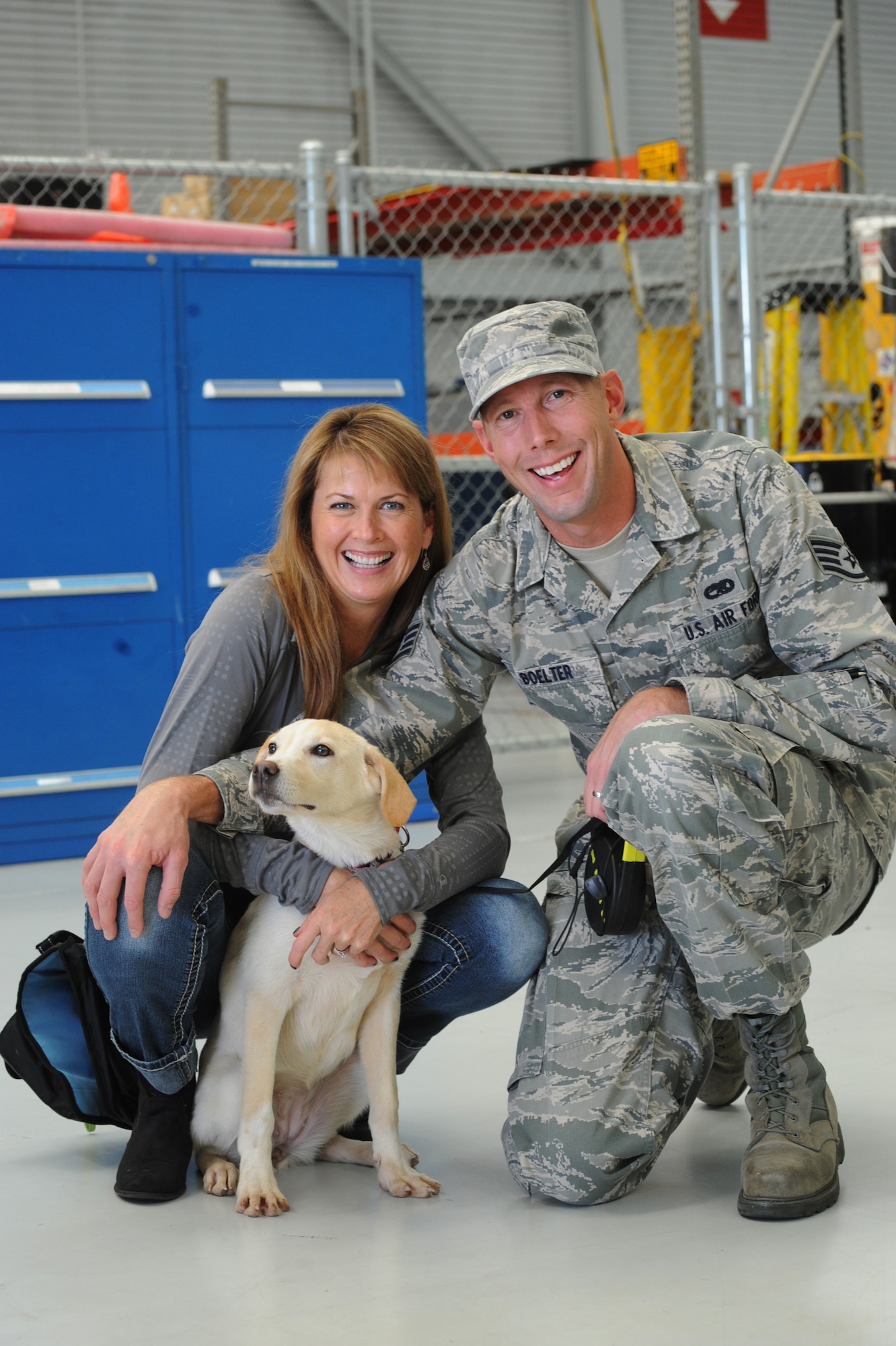 Oregon Air National Guard Staff Sgt. Joshua Boelter along with his wife Sara, pause for a photograph with Luna, a Romania puppy rescued during deployment and reunited, Nov. 5, 2015, Portland Air National Guard Base, Ore. (U.S. Air National Guard photo by Tech. Sgt. John Hughel, 142nd Fighter Wing Public Affairs/Released)