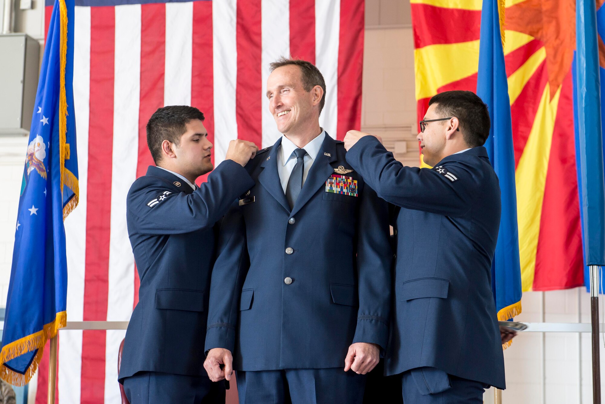 TUCSON, Ariz. – Airman 1st Class Ricardo Badilla, left, and Airman 1st Class Edwin Martinez, right, pin silver stars on newly-promoted Brig. Gen. Howard P. Purcell, 162nd Wing Commander, Nov. 7 at the 162 Wing at the Tucson International Airport. Breaking from tradition, Purcell chose the most junior enlisted Airmen from each group to perform the honor of pinning on the service dress jacket’s silver stars and placing new shoulder boards for his dress shirt – embodying a commitment to his own Air National Guard family. (U.S. Air National Guard photo by Tech. Sgt. Hollie A. Hansen /Released)
