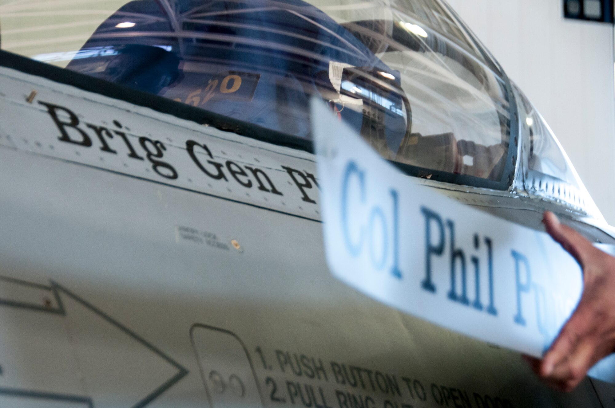 TUCSON, Ariz. -- Out with the old, in with the new. In a tradition for Air Force command pilots at the 162nd Wing, an old nameplate is removed from an F-16 Fighting Falcon, revealing a new plate with a new rank for newly-promoted Brig. Gen. Howard P. Purcell, 162nd Wing Commander. More than 1,000 Airmen and distinguished guests converged Nov. 7 at the 162nd Wing to witness the promotion ceremony, held at the Tucson International Airport. (U.S. Air National Guard photo by Senior Airman Jackson Hurd/Released)