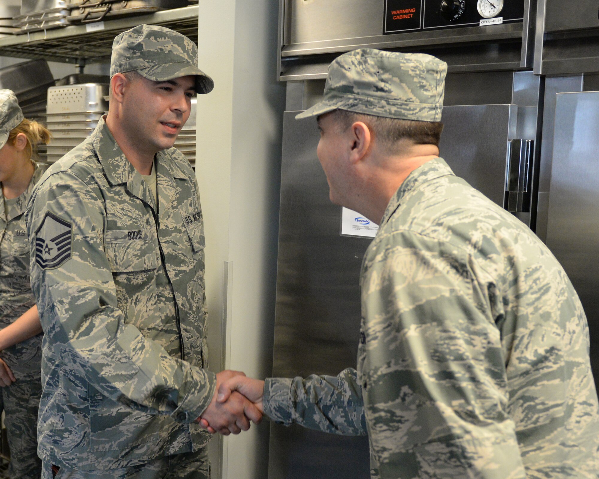 U.S. Air Force Brig. Gen. Michael. R. Taheri, right, commander Air National Guard Readiness Center at Joint Base Andrews, Maryland, shakes hands with Master Sgt. Brad Bogue during a coin presentation recognizing outstanding Airmen, Pease Air National Guard Base, New Hampshire, Nov. 7, 2015. (U.S. Air National Guard photo by Staff Sgt. Curtis J. Lenz)