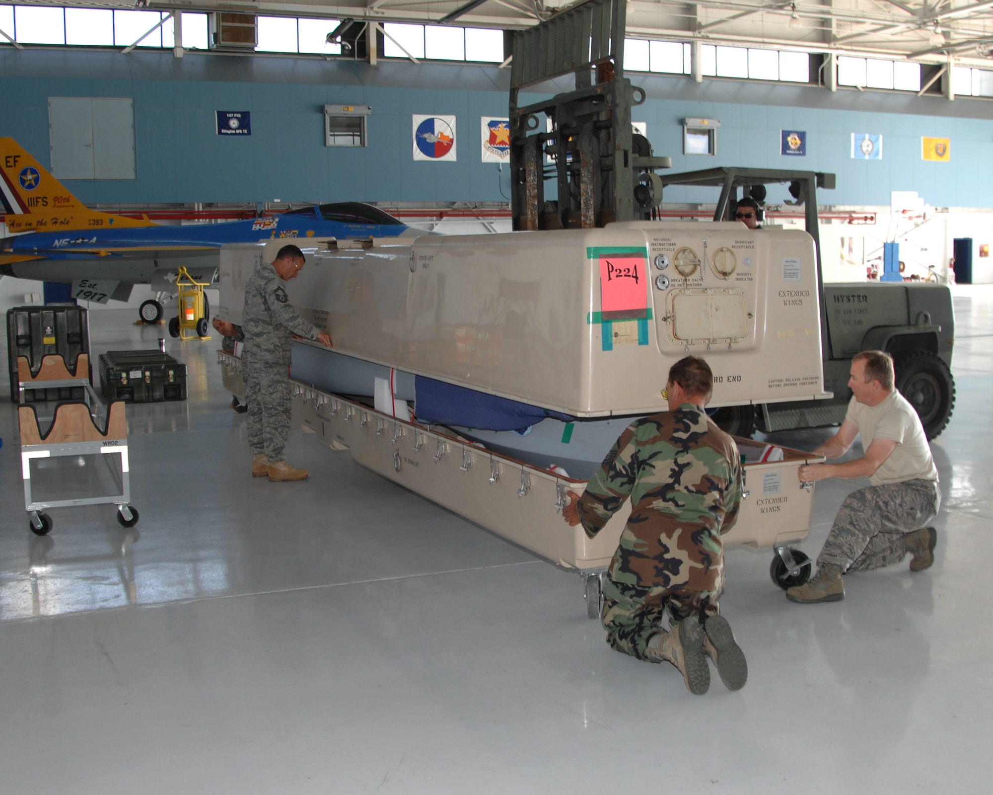Members of the 147th Reconnaissance Wing Maintenance Wing open the crate holding an MQ-1 Predator at Ellington Field Joint Reserve Base in Houston on August 18, 2009. The wing transitioned from the F-16 to the MQ-1 and this is the first Predator delivered to the unit.