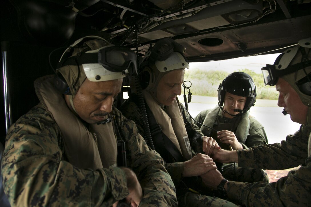 Lt. Gen. Michael G. Dana, left center, and Brig. Gen. Tracey W. King, far right, prepare for an air tour aboard a UH-1Y Huey helicopter Nov. 5 on Camp Courtney, Okinawa, Japan. The air tour allowed Dana to view strategic access points on Okinawa, as well as the strategic resources and high readiness of Marine Corps Installations Pacific camps and facilities in daily support of operations across the Indo-Asia-Pacific region. The visit also drew attention to the importance of financial and manpower resources within MCIPAC. Dana is the deputy commandant for installations and logistics. King is the commanding general of the 3rd Marine Logistics Group, III Marine Expeditionary Force.