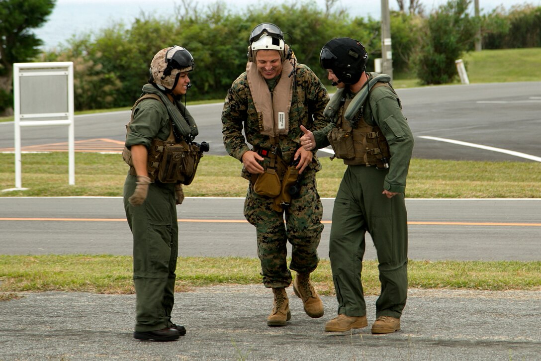 Lt. Gen. Michael G. Dana, center, prepares to board a UH-1Y Huey helicopter for an air tour Nov. 5 on Camp Courtney, Okinawa, Japan. The air tour allowed Dana to view strategic access points on Okinawa, as well as the strategic resources and high readiness of Marine Corps Installations Pacific camps and facilities in daily support of operations across the Indo-Asia-Pacific region. The visit also drew attention to the importance of financial and manpower resources within MCIPAC. Dana is the deputy commandant for installations and logistics.