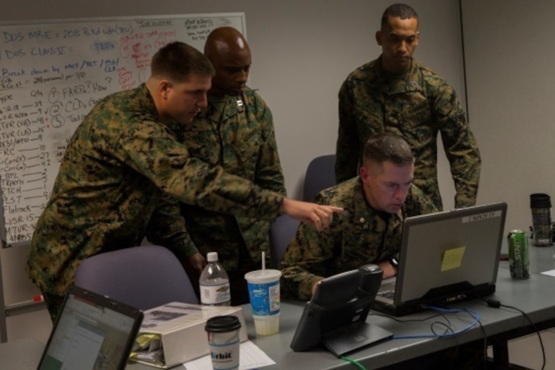Marines from Combat Logistics Regiment 25 work together to input operational statuses during the 2nd Marine Logistics Group Staff Exercise at Camp Lejeune, N.C., Nov. 4, 2015. Subordinate commands in 2nd MLG came together during the two-week exercise to establish a basis of standard operating procedures. Throughout the week, the commands progressively built rapport and familiarized themselves through constructive workshops and briefs.