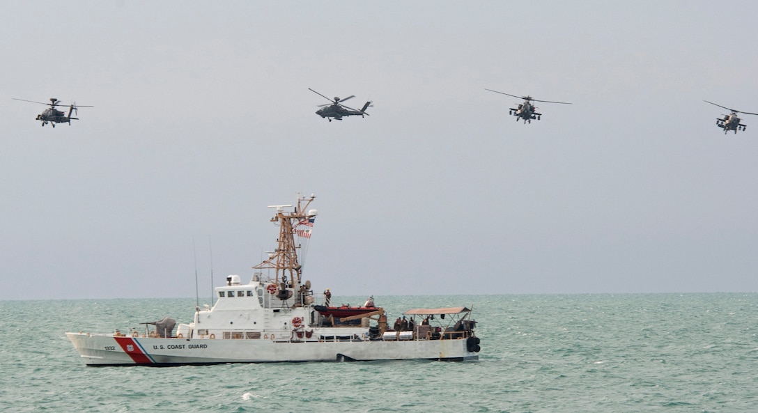 Two U.S. AH-64D Apache helicopters and two Kuwaiti Apache helicopters fly together over the Island-class cutter patrol boat USCGC Wrangell conducting mock sea-and-air strikes during a bilateral training exercise in the Arabian Gulf, Nov. 3, 2015. U.S. Navy photo by Petty Officer 2nd Class Torrey W. Lee