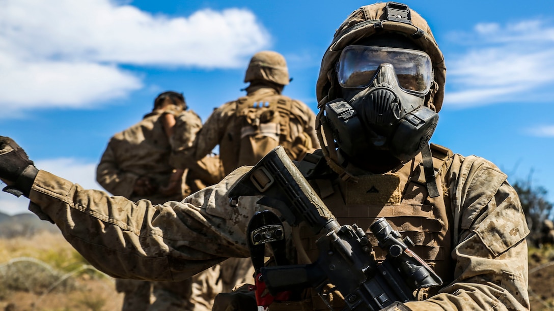 After being gassed, a Marine with Kilo Company, 3rd Battalion, 3rd Marine Regiment, guides Marines through concertina wire during training exercise Lava Viper, a staple of their pre-deployment training, at Range 10 at Pohakuloa Training Area, Hawaii, Nov. 4, 2015. The purpose of the training was to provide Marines within the company with an opportunity to utilize various tactics and weapons while organizing within the platoons to accomplish a common mission. Lava Viper provides the Hawaii-based Marines with an opportunity to conduct various movements, live-fire and tactical training before departing for Integrated Training Exercise aboard Marine Air-Ground Combat Center Twentynine Palms, Calif., where the battalion will train and be evaluated as a whole.