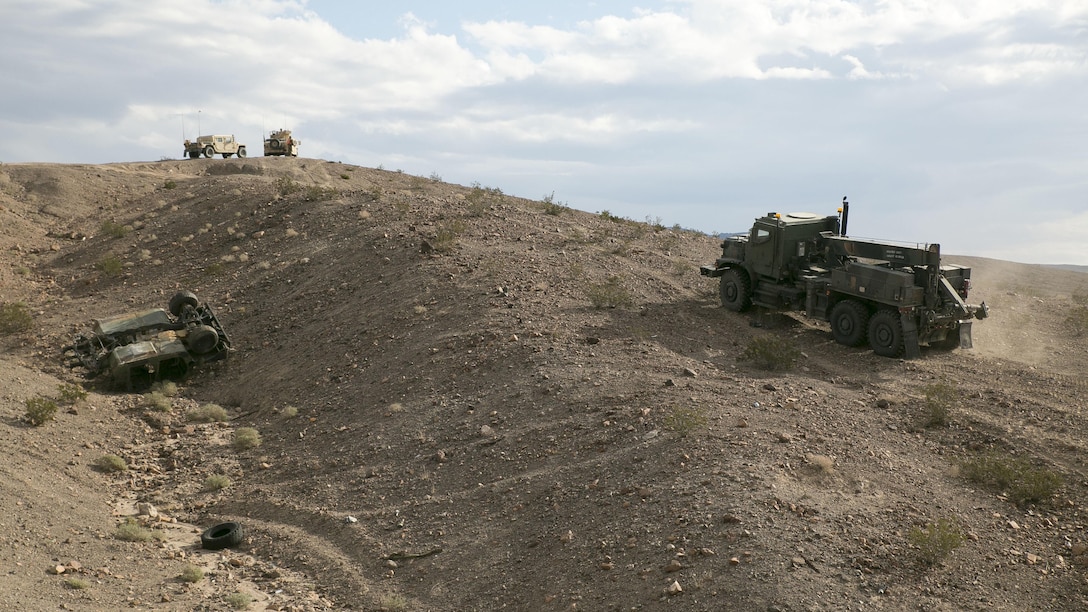 Marines with Transportation Services Company, Combat Logistics Battalion 2, prepare to recover a staged flipped vehicle during a live-fire scenario as part of Integrated Training Exercise 1-16 at Marine Air Ground Combat Center Twentynine Palms, Calif., Nov. 4, 2015. Military police from 2nd Law Enforcement Battalion provided security during the exercise, allowing the wrecker team to focus on the mission at hand. 