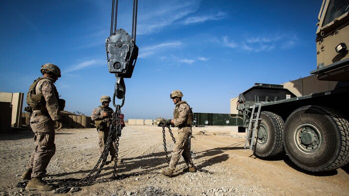 U.S. Marines with Engineer Company, Combat Logistics Battalion 1, and Marine Wing Support Squadron 372, currently deployed in support of Special Purpose Marine Air Ground Task Force-Crisis Response-Central Command 16.1, prepare the hook block of a MAC-50 Crane to move Alaskan walls at Al Taqaddum Air Base, Iraq, Oct. 25, 2015. The 12-ton T-walls are placed around key structures to provide protection from shrapnel.