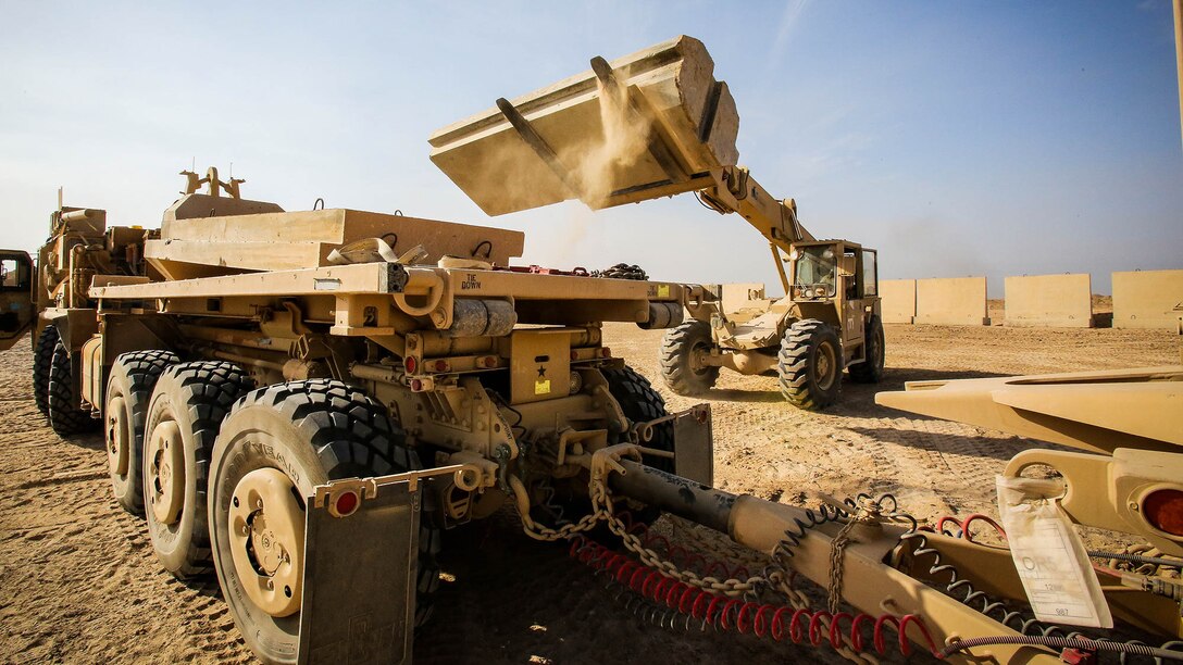 U.S. Marines with Engineer Company, Combat Logistics Battalion 1, and Marine Wing Support Squadron 372, currently deployed in support of Special Purpose Marine Air Ground Task Force-Crisis Response-Central Command 16.1, load Alaskan walls onto a Palletized Loading System to be transported at Al Taqaddum Air Base, Iraq, Oct. 25, 2015. These coalition barriers are placed around key structures to provide protection in the fight against the Islamic State of Iraq and the Levant. 
