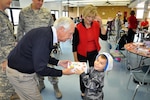 Kentucky Governor Steve Beshear and First lady, Jane Beshear, examine Leland Caty's specially decorated keep-sake during a holiday celebration held in Idependence, Ky., on Dec. 3, 2011. Caty's step-father, Army Spc. Neal McIver is a member of the 1204th Aviation Support Battalion of the Kentucky National Guard.
