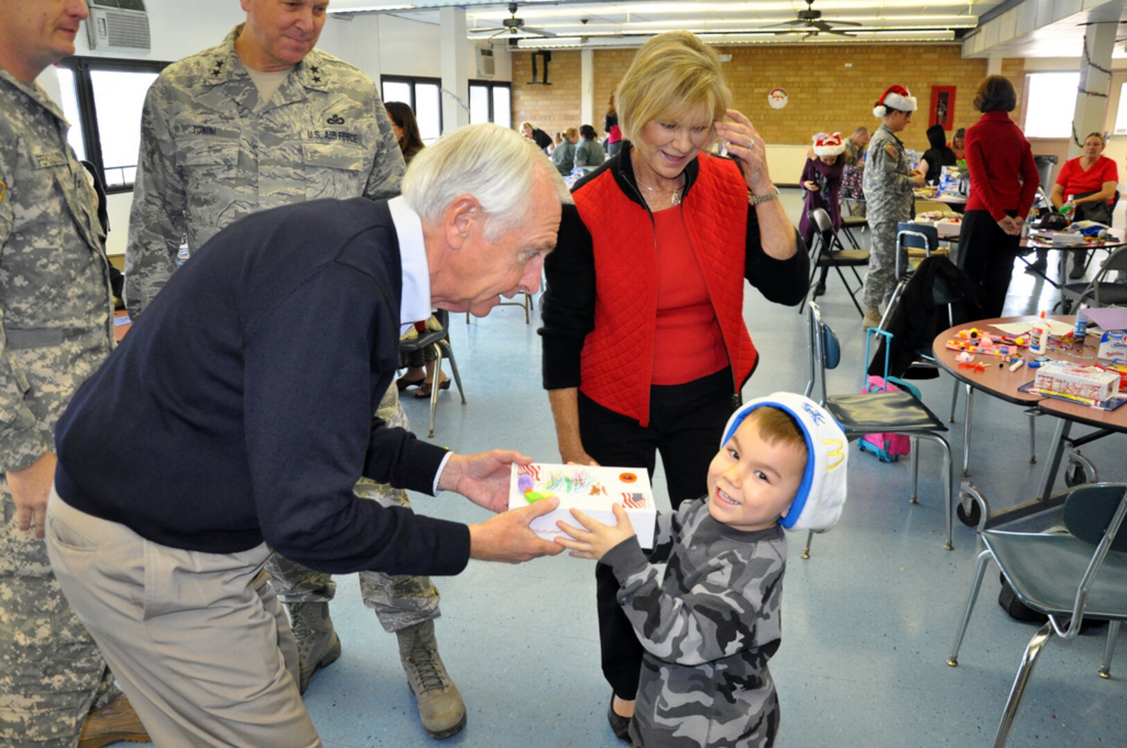 Kentucky Governor Steve Beshear and First lady, Jane Beshear, examine Leland Caty's specially decorated keep-sake during a holiday celebration held in Idependence, Ky., on Dec. 3, 2011. Caty's step-father, Army Spc. Neal McIver is a member of the 1204th Aviation Support Battalion of the Kentucky National Guard.