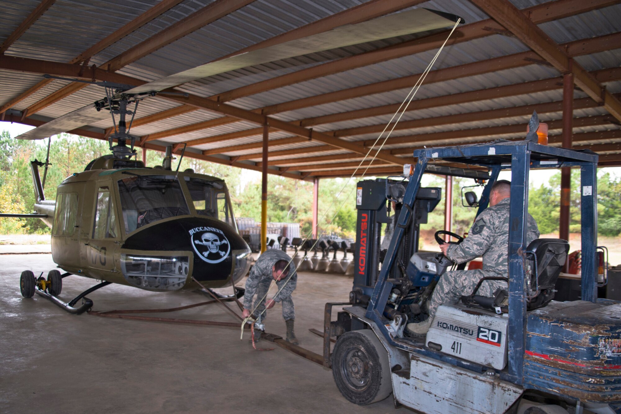 U.S. Air Force Staff Sgt. Brandon Thelen, sheet metal craftsman, 913th Maintenance Squadron, connects a towing hitch to a forklift operated by Master Sgt. Jerry Killian, fabrication supervisor, 913 MXS, at the city recycling center in Jacksonville, Ark., Nov. 3, 2015. The Airmen were preparing to move a Bell UH-1C Iroquois Vietnam era helicopter they helped restore for the Jacksonville Museum of Military History back to the museum. (U.S. Air Force photo by Master Sgt. Jeff Walston/Released)