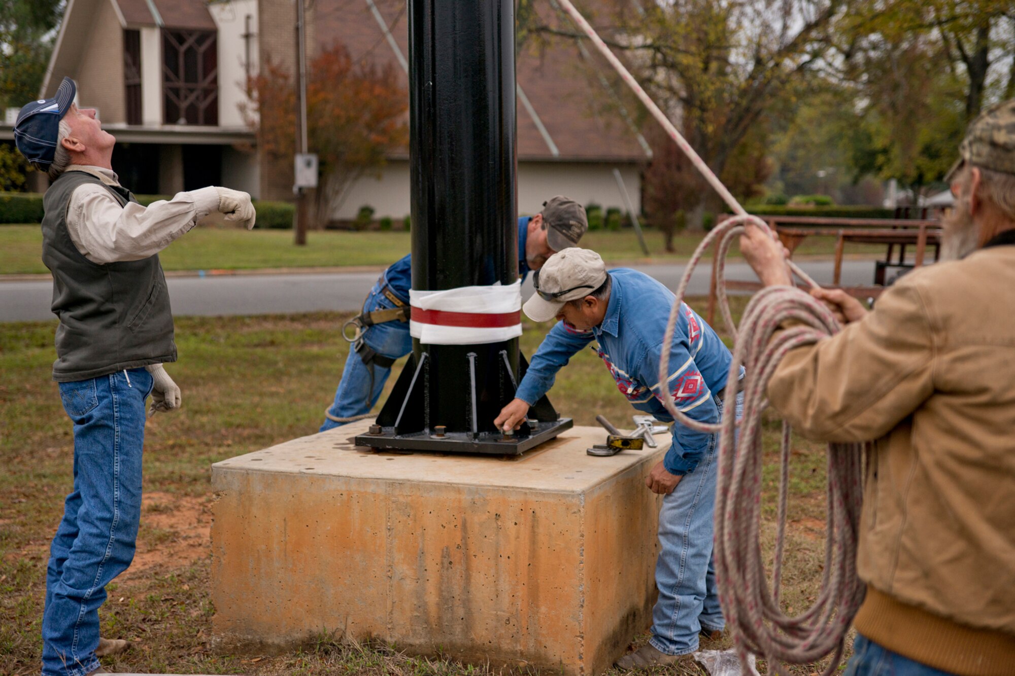 Workers reinstall the repainted pedestal for a Bell UH-1C Iroquois helicopter at the Jacksonville Museum of Military History in Jacksonville, Ark., Nov. 4, 2015. Both the military and civilian communities restored the Vietnam era helicopter to its original combat color scheme for future visitors to the museum. (U.S. Air Force photo by Master Sgt. Jeff Walston/Released)