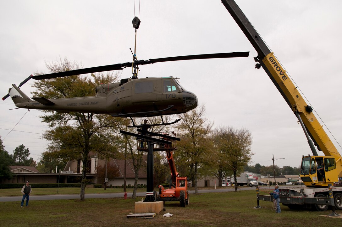 Hank Fuhrman guides a newly restored Bell UH-1C Iroquois helicopter from the Vietnam era into place on a pedestal at the Jacksonville Museum of Military History in Jacksonville, Ark., Nov. 4, 2015. The return of the helicopter to the museum marks the end of a restoration project that began in June 2015. (U.S. Air Force photo by Master Sgt. Jeff Walston/Released)