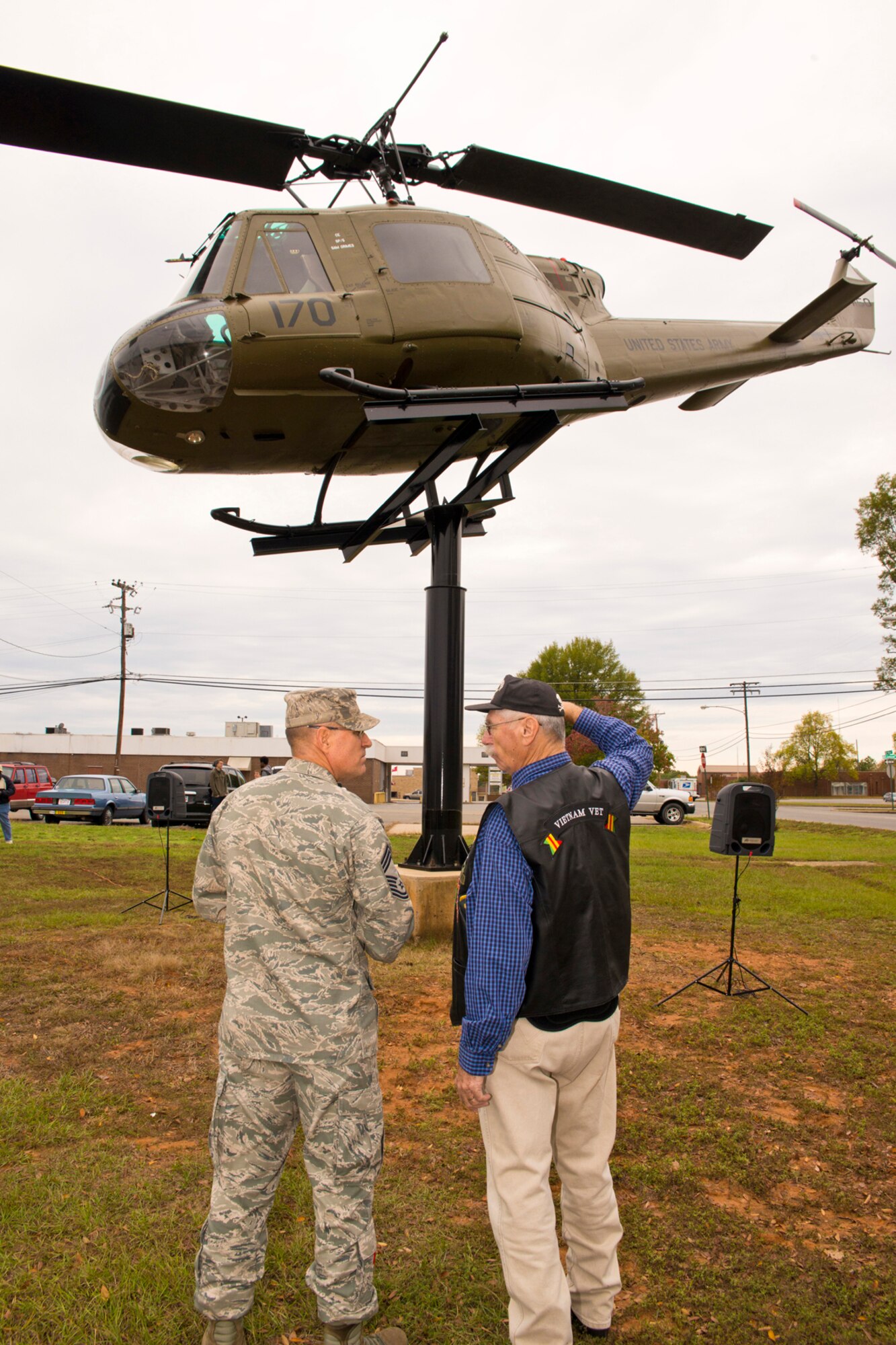 U.S. Air Force Chief Master Sgt. Ralph E. Babcock II, superintendent, 913th Aircraft Maintenance Squadron listens to “War Stories” from Sam Grimes before a dedication ceremony at the Jacksonville Museum of Military History in Jacksonville, Ark., Nov. 7, 2015. Grimes, who travelled from Snowflake, Ariz., with Trudy, his wife of 35 years, was a crew chief on the actual Bell UH-1C Iroquois helicopter above them during a nine-month period in Vietnam from April 1967 – January 1968. (U.S. Air Force photo by Master Sgt. Jeff Walston/Released)


