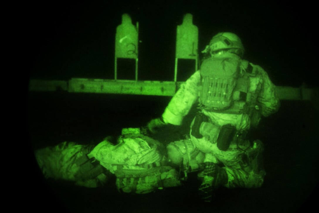 As seen through a night-vision device, a U.S. Marine assesses a simulated casualty during a deck shoot aboard the amphibious assault ship USS Essex in the Indian Ocean, Oct. 31, 2015. The Marine is assigned to the 15th Marine Expeditionary Unit’s Maritime Raid Force. The 15th MEU, embarked on the ships of the Essex Amphibious Ready Group, is deployed to maintain regional security in the U.S. 5th Fleet area of operations. U.S. Marine Corps photo by Sgt. Anna Albrecht 