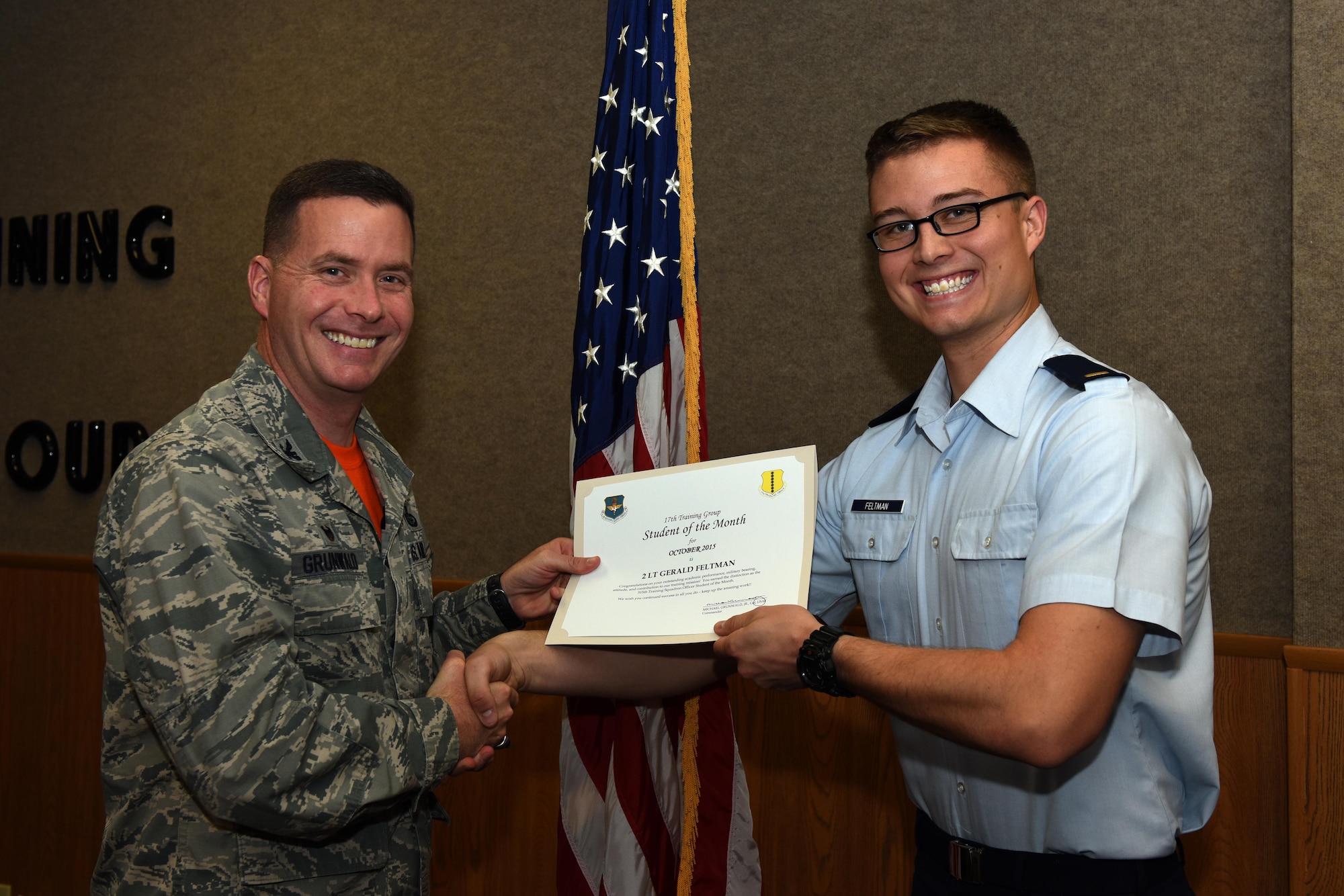 U.S. Air Force Col. Michael Grunwald Jr., 17th Training Group Commander, presents the 315th Training Squadron Student of the Month award for October 2015 to 2nd Lt. Gerald Feltman in the Brandenburg Hall on Goodfellow Air Force Base, Texas, Nov. 6, 2015. (U.S. Air Force photo by Airman Chase Sousa/Released)