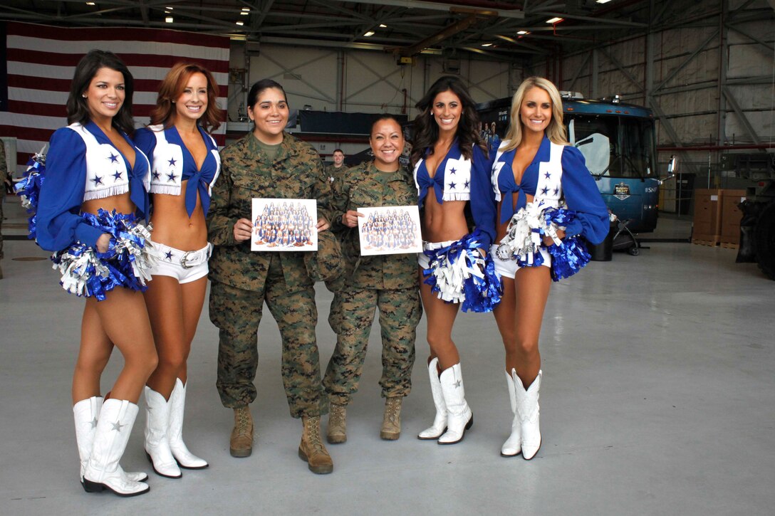 Cheerleaders from the Dallas Cowboys take pictures and sign autographs with service members and their families during the Cowboys Military Appreciation event on Nov. 6, 2015 aboard Naval Air Station Joint Reserve Base Fort Worth, Texas. The cheerleaders visited the base to show the support of local service members and their families on behalf of the Dallas Cowboys and the Gene and Jerry Jones Family Foundation.