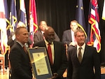 Pearl Pearson, Jr., (center), was presented with the 2015 Outstanding DoD Employee with a Disability Award by Brad R. Carson, (left) Undersecretary of Defense for Personnel and Readiness, and Terry Phillips, (right) Preservation, Packaging, Packing and Marking Branch Chief at the 35th annual Department of Defense Disability Awards ceremony held in the Pentagon Auditorium on Oct. 29.