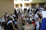 Army Capt. Carla Getchell, women empowerment lead, talks with girls at the Nasaji Gulbahar Girls School Dec. 3, 2011. A massive donation of 600 school supply boxes was donated to the Afghan children as part of an project through the annual National Guard Youth Symposium held in Louisville, Ky., earlier this year. Army National Guard Sgt. Heather Carrier and Sgt. Jerred Stevens coordinated with people they knew back in their home communities to collect the supplies.