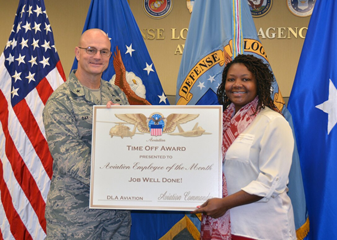 DLA Aviation Business Process Support Directorate's Catina Jeffrey, a supply systems analyst, accepts the September 2015 Employee of the Month Award from DLA Aviation Commander Air Force Brig. Gen. Allan Day Nov. 5, 2015 during a ceremony in Building 34 on Defense Supply Center Richmond, Virginia. 