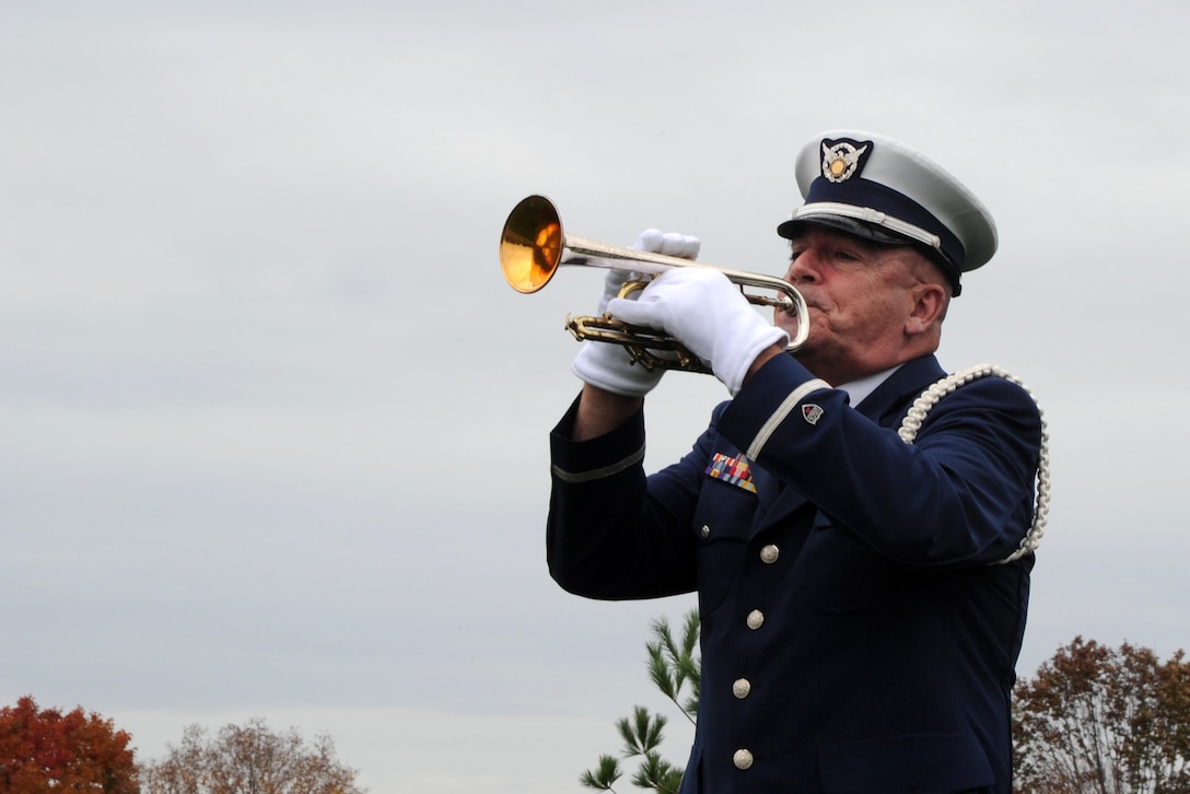 A lone bugler plays taps during the Coast Guard's Flags Across America event at Arlington National Cemetery in Arlington, Va., Nov. 7, 2015. During the event, volunteers placed Coast Guard flags and national ensigns on the graves of Coast Guardsmen ahead of Veterans Day. U.S. Coast Guard photo by Petty Officer 3rd Class Lisa A. Ferdinando